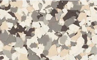 A close-up of a surface with scattered chips in shades of gray, beige, white, and black.