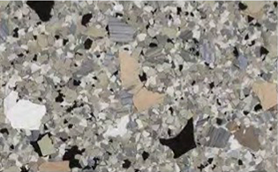 Close-up of a terrazzo surface with variously sized and colored stone and glass chips embedded in a light matrix.